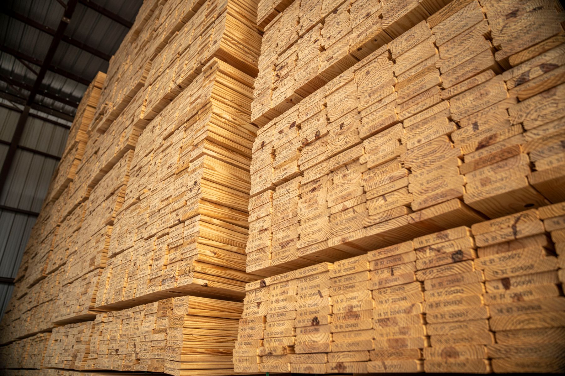 Stacks of lumber stored in an industrial warehouse